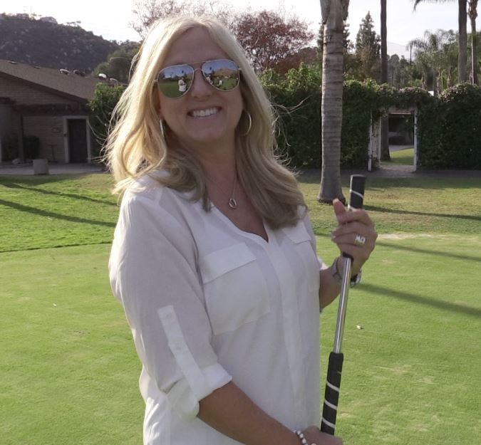 Linda Kopperud holding on the face-on putters sold by USA Golf Masters at the golf course.