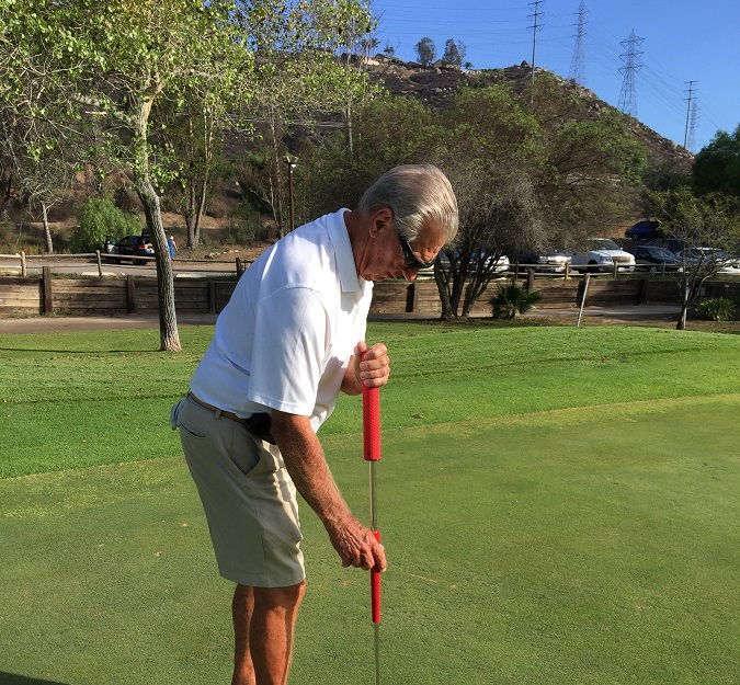 Mr. Barry Robbins using the face-on putting style on the golf course with a USA Golf Masters putter.