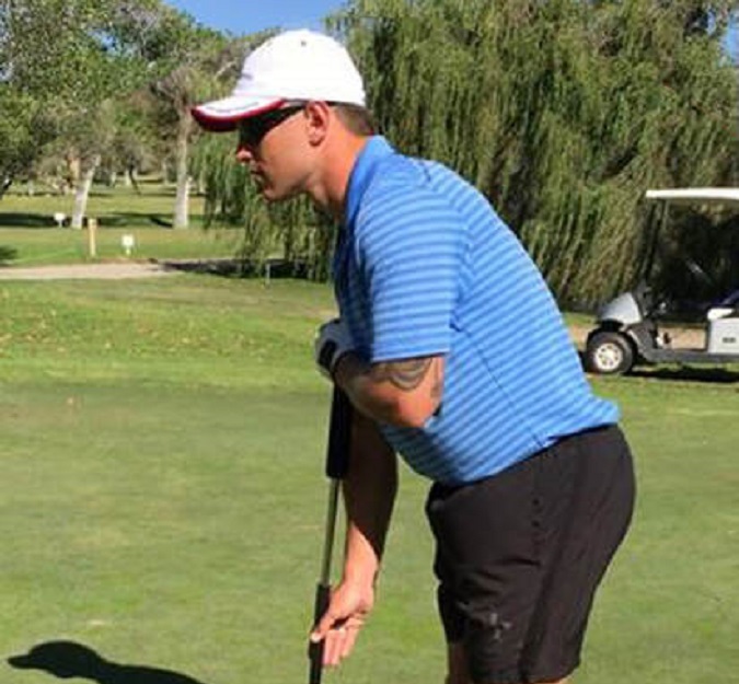 A close up of professional golfer Shane Stone using the face-on putter at the golf course.